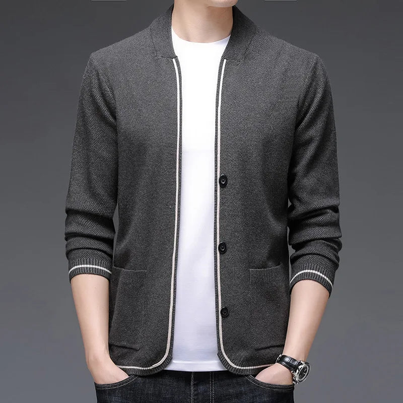 Gray jacket with white trim worn by a person on a gray background