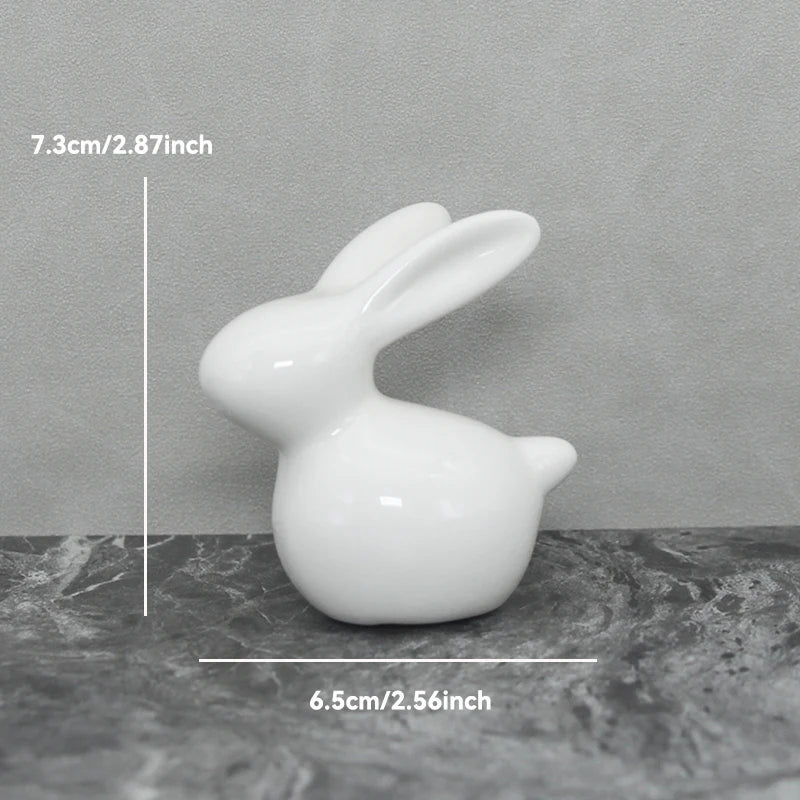 White ceramic rabbit figurine on a gray surface with measurements indicated.