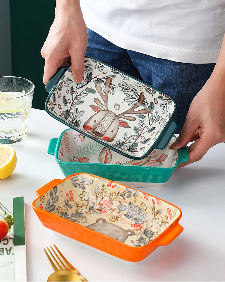 Two ceramic trays with floral and deer designs on a table.