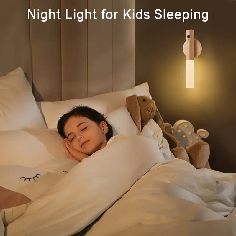 Child sleeping in bed with a night light on the wall above.
