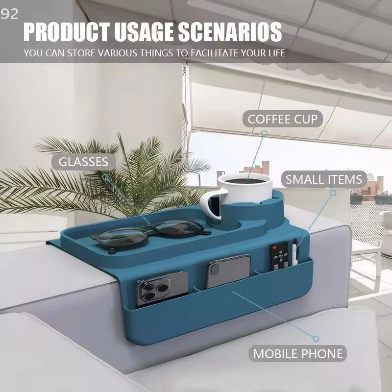 Blue sofa tray with compartments holding a coffee cup, glasses, and small items on a couch.