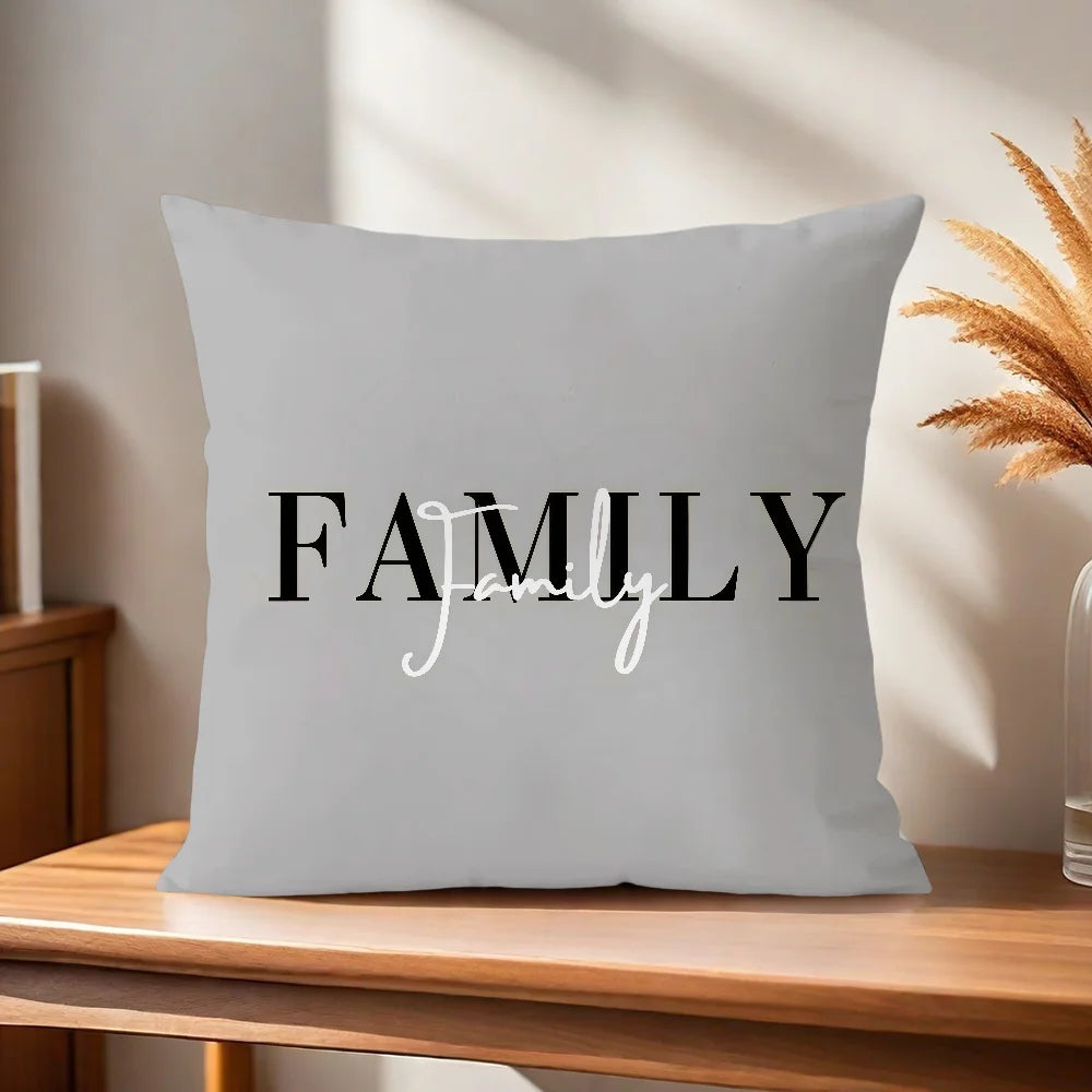 Gray pillow with 'FAMILY' text on a wooden surface