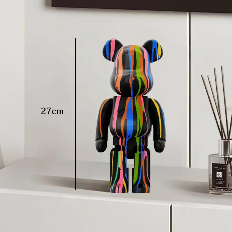 Colorful striped bear figure on a white surface with a measurement label