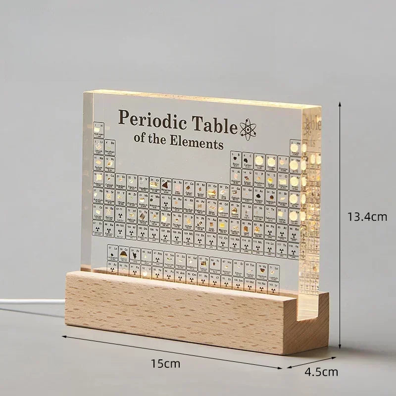 Light-up periodic table of elements with wooden base and measurements on a gray background