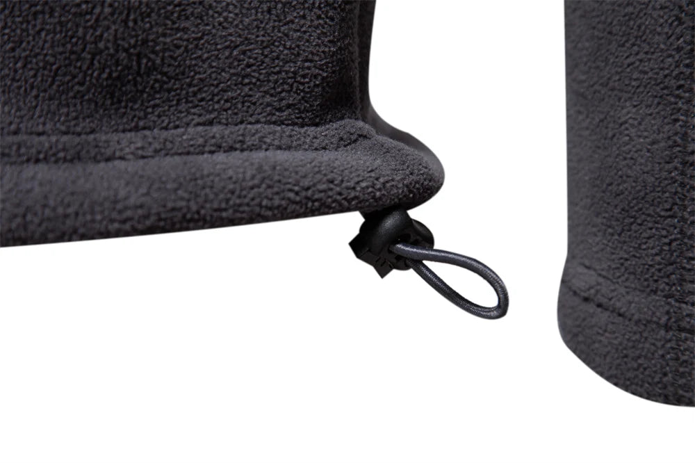 Close-up of a black fleece jacket with a zipper on a white background