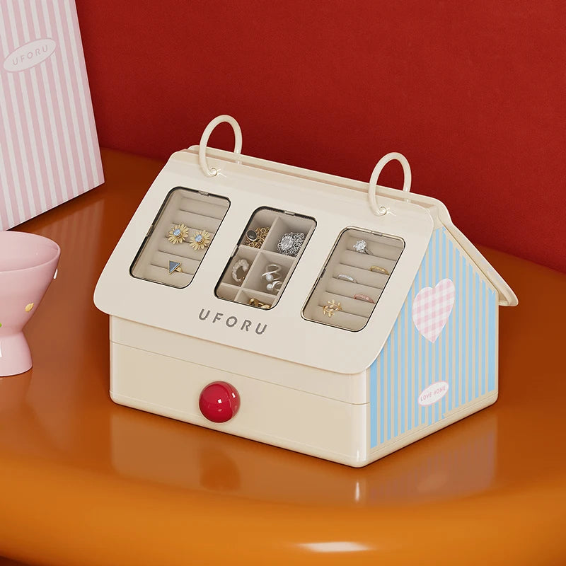 House-shaped jewelry organizer with earrings on a red background