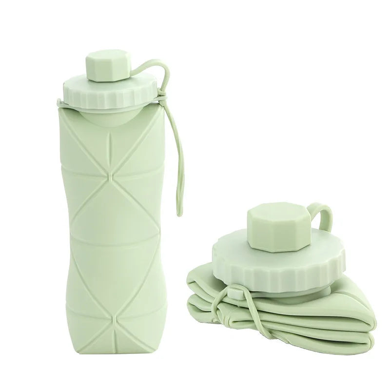 Collapsible green silicone water bottle with carrying strap on a white background
