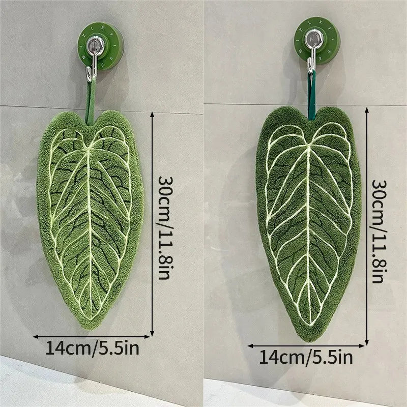 Leaf shaped hanging hand towel made from soft coral fleece fabric displayed beside a bathroom sink