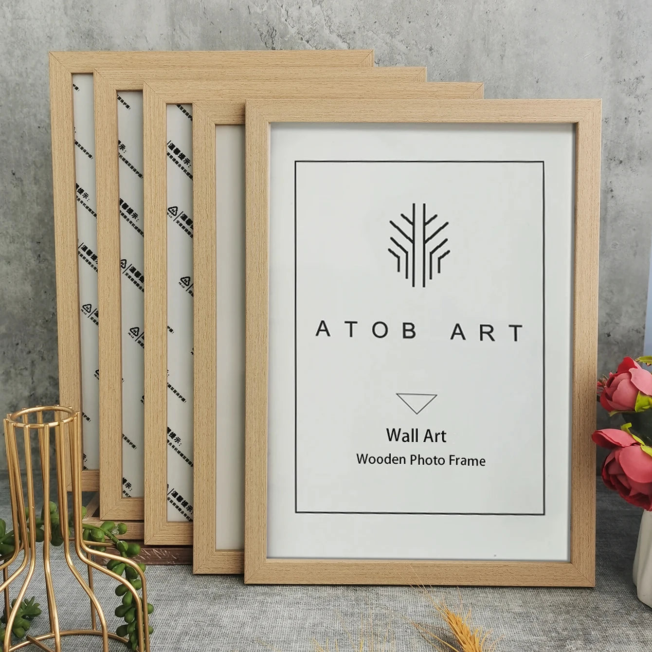 Wooden photo frames with 'ATOB ART' branding on a concrete surface.