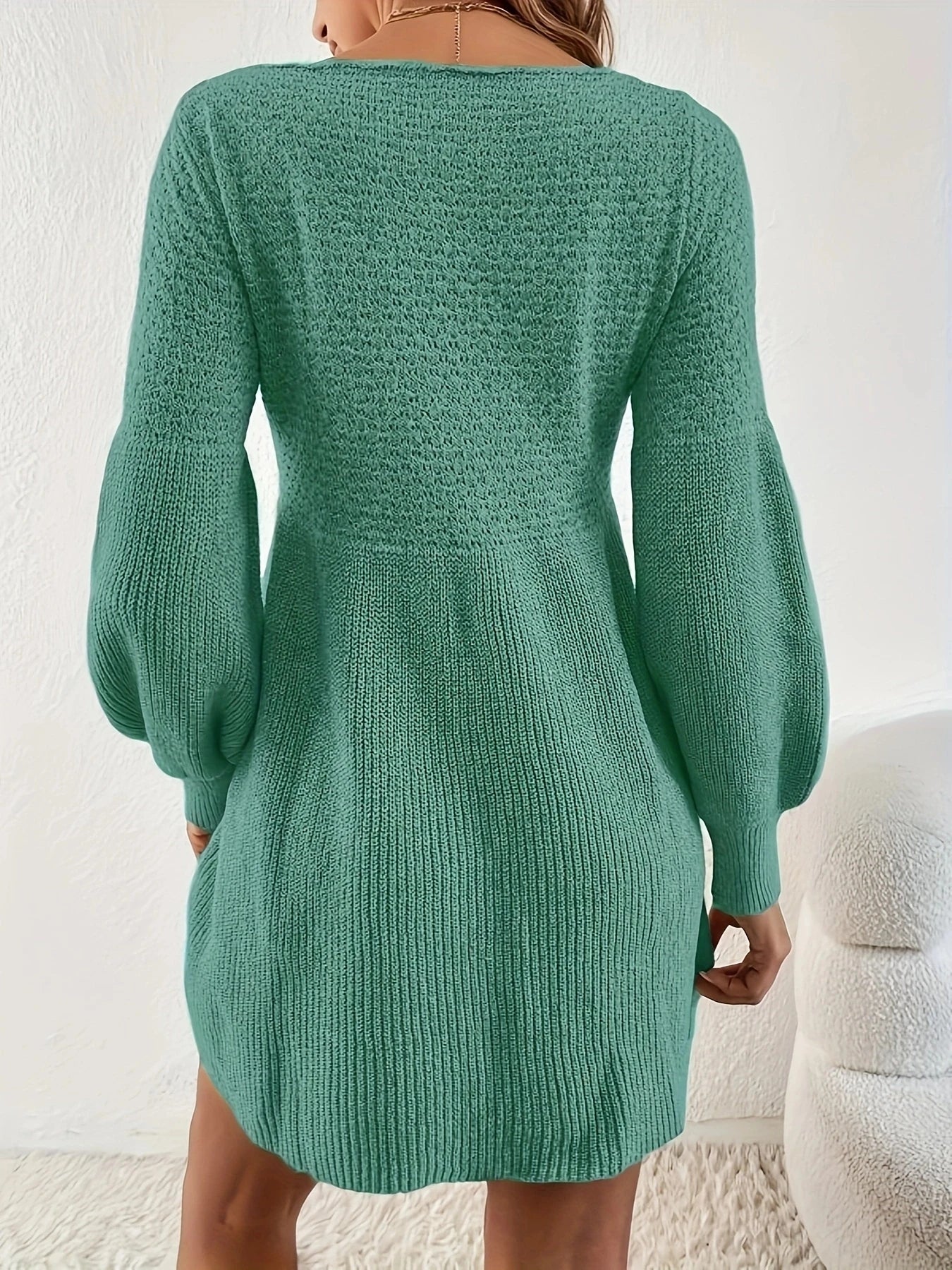 Green knitted dress worn by a person against a white background