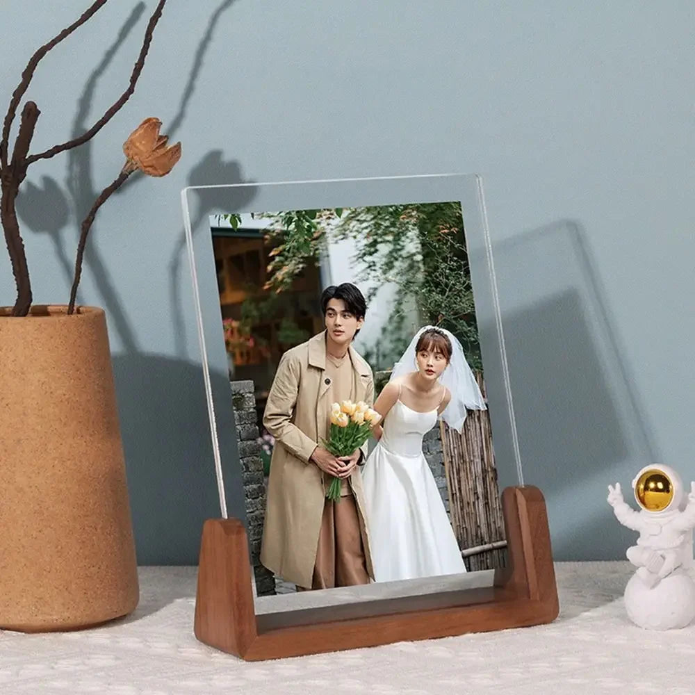 Wooden Modern photo frame with a couple in wedding attire on a wooden stand against a light blue wall.