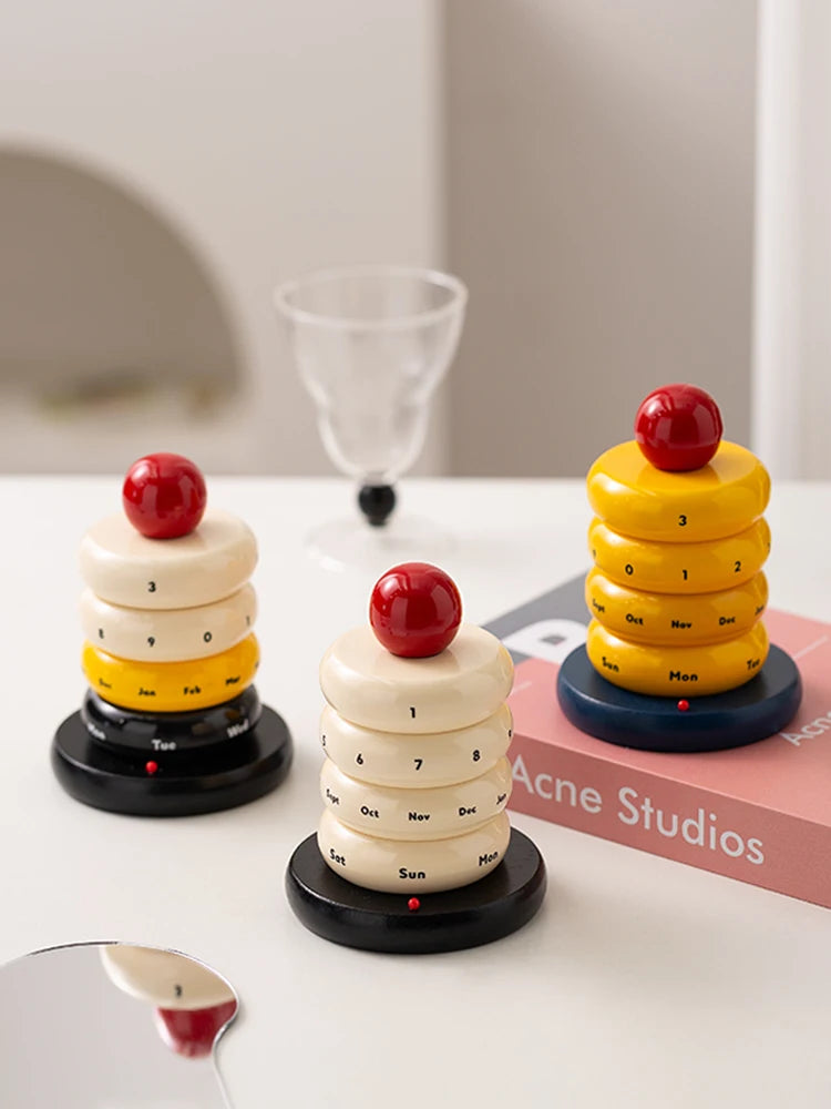 3 x Modern rotating desk calendasr with minimalist Scandinavian styling shaped as a cake with a cherry on top