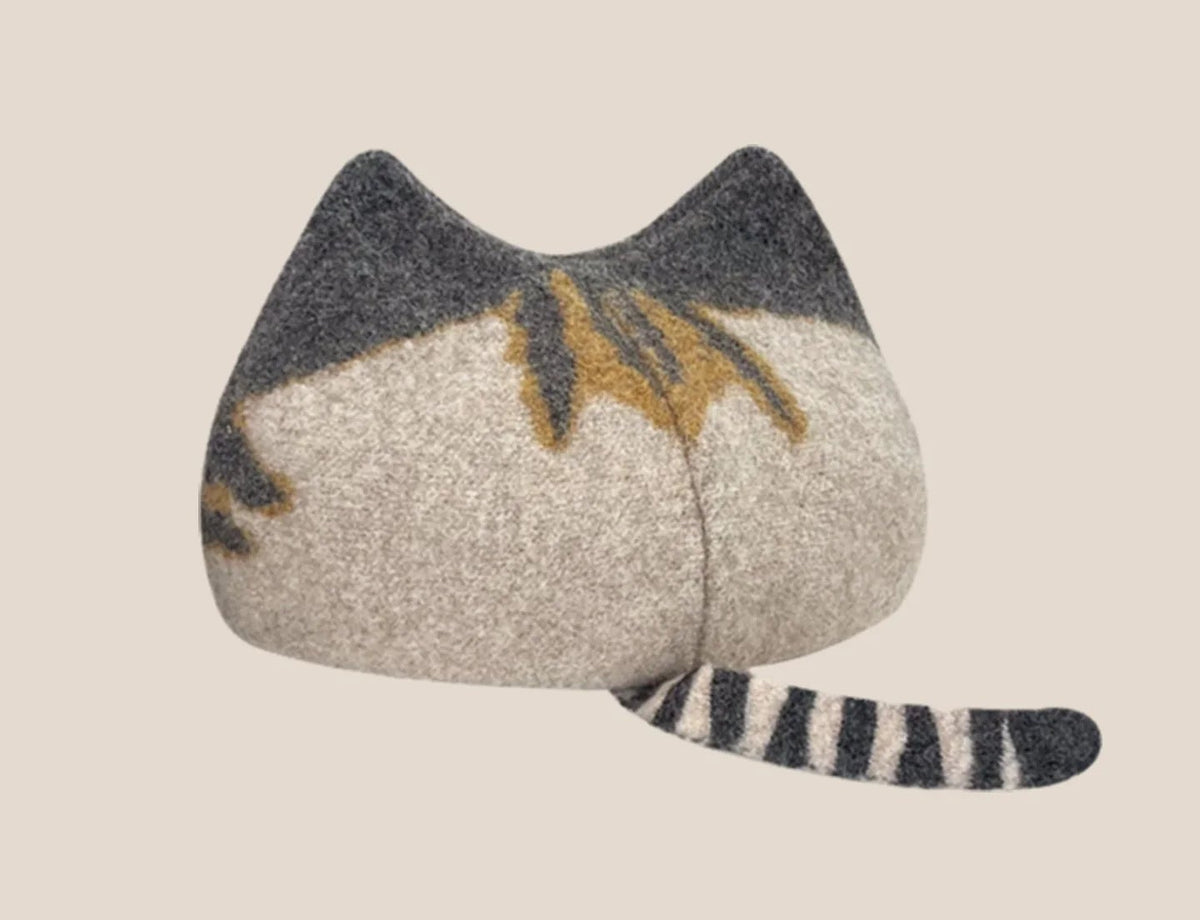 A wool cat-shaped hat in beige and gray with yellow and black stripe details, shown on a light beige background 