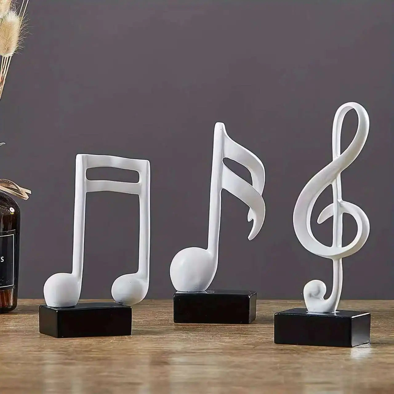 Set of three modern resin musical note sculptures with black bases displayed as contemporary home décor, available in black, white and gold finishes.