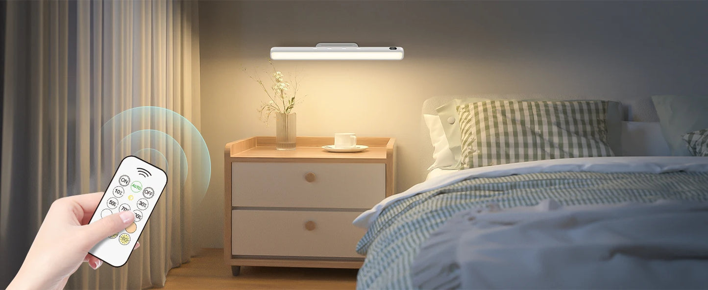 Bedroom scene with a night light on the wall and a remote control held by a hand.