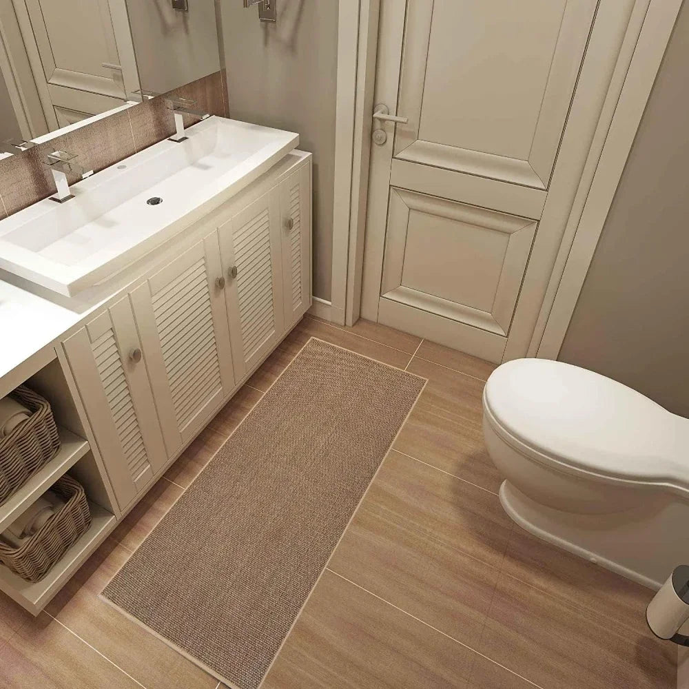 Bathroom with a toilet, sink, and cabinets on a wooden floor.