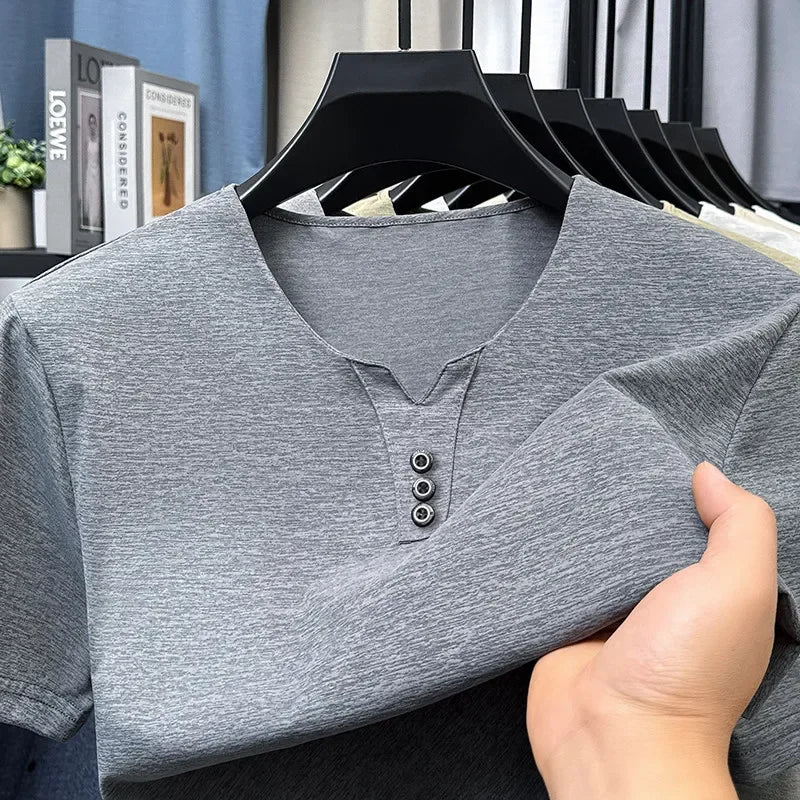 Gray henley shirt on a hanger with a blurred indoor background