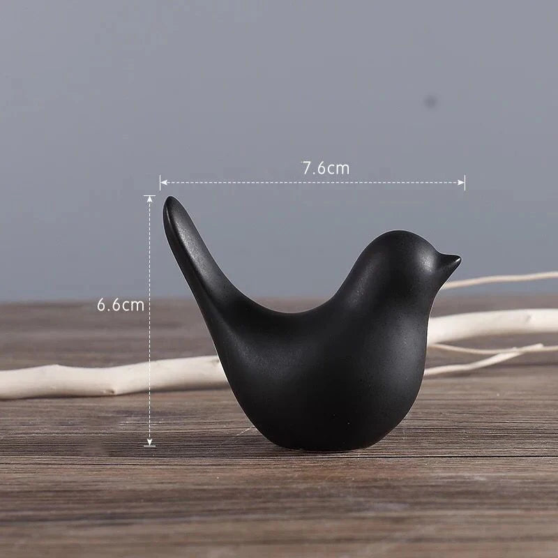 Black bird-shaped object on a wooden surface with measurements indicated.