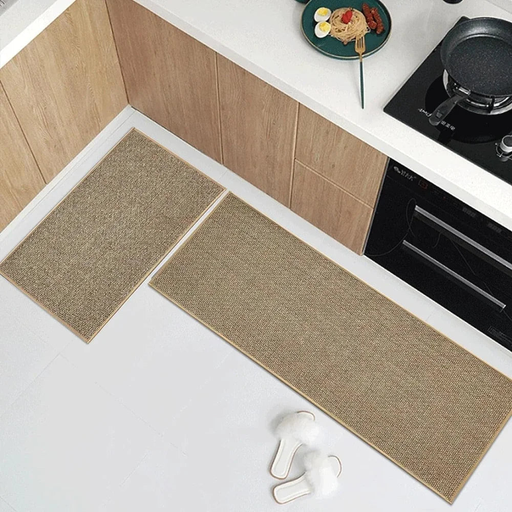 Two beige kitchen mats on a white floor with wooden cabinets and a stove in the background.