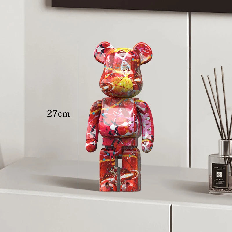 Colorful bear-shaped figure on a white surface with a measurement label, next to a diffuser.