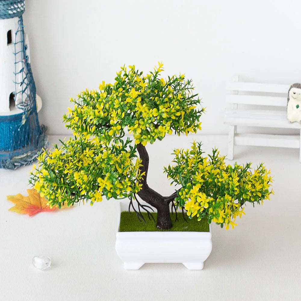 Potted plant with yellow flowers and green leaves on a white surface