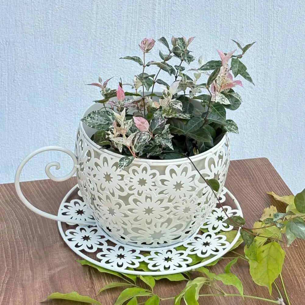 Decorative white teacup with plant on a wooden surface and light blue background