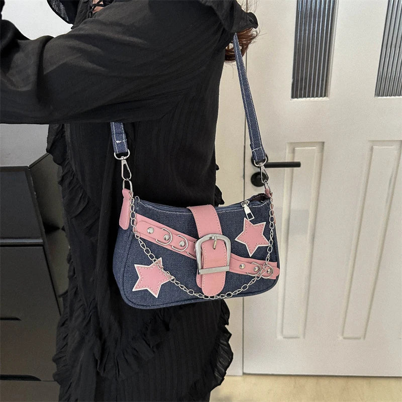 Person holding a denim and pink handbag with star designs.
