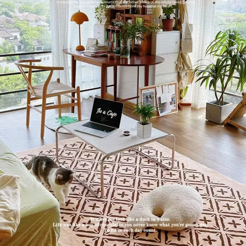 Modern living room with a laptop on a coffee table, a cat, and decorative elements.