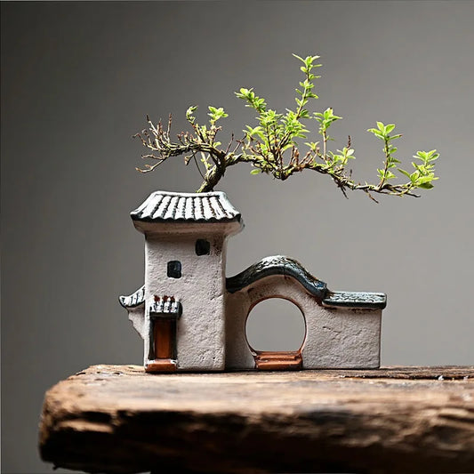 Ceramic house planter with Jiangnan style design featuring tiled roof and wooden door, used as a succulent or bonsai pot on wooden surface