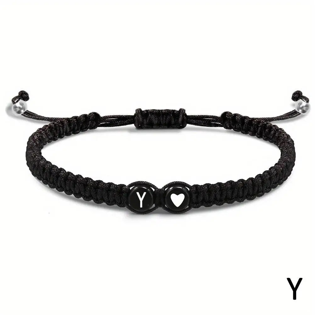 Black braided bracelet with letter 'Y' charm on a white background