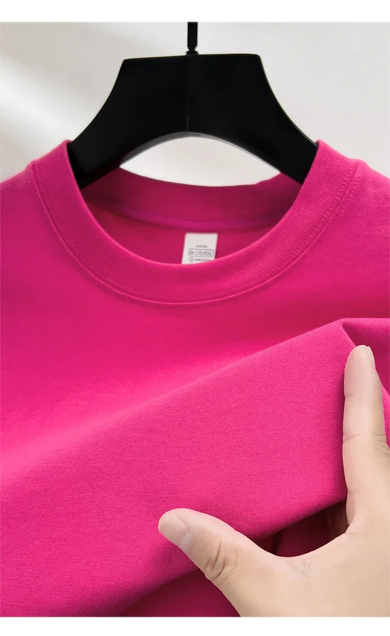 Pink sweatshirt on a hanger with a hand touching the fabric