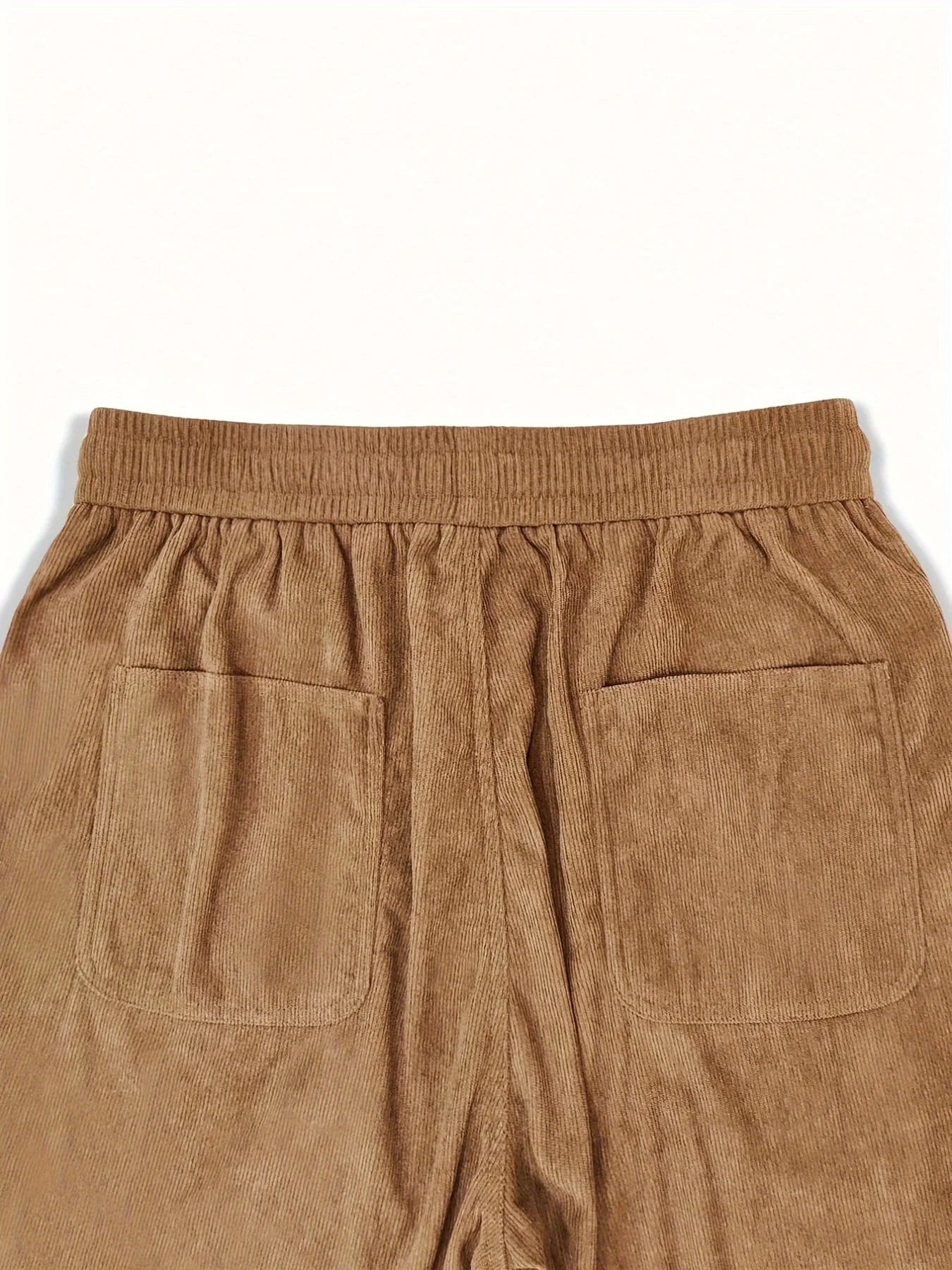 Close-up of brown corduroy pants with a white background
