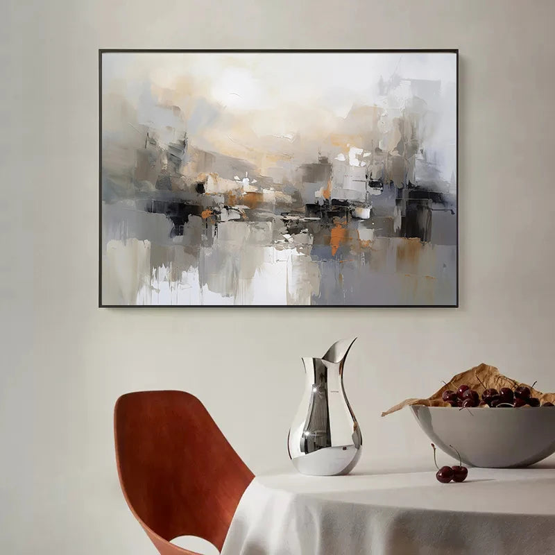 Abstract painting on a wall above a table with a chair and decorative items.