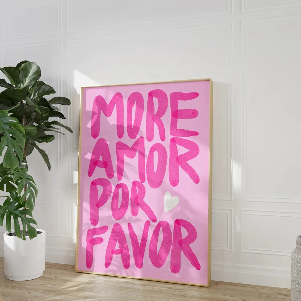 Framed artwork with pink text 'More Amor Por Favor' on a white wall.