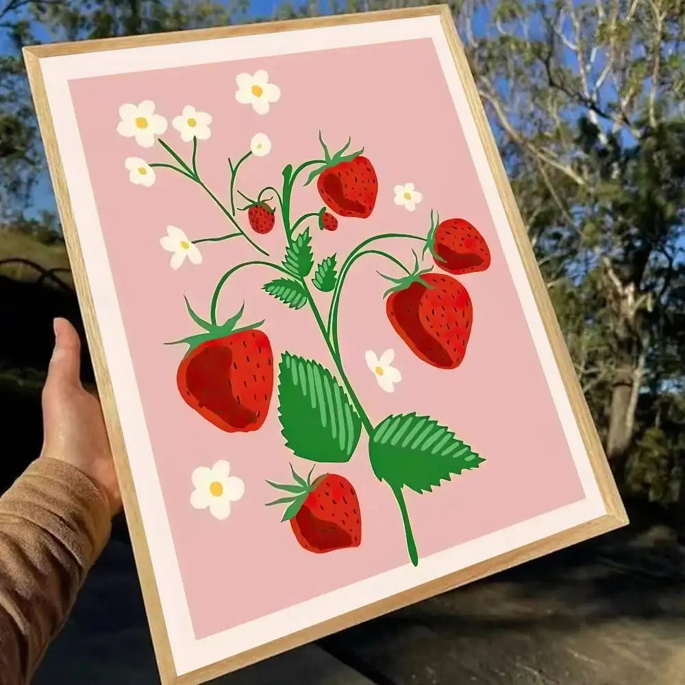 Framed artwork of strawberries and flowers on a pink background held outdoors.