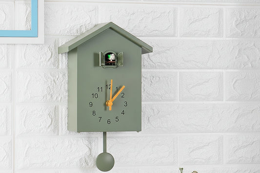 Green cuckoo clock on a white textured wall  