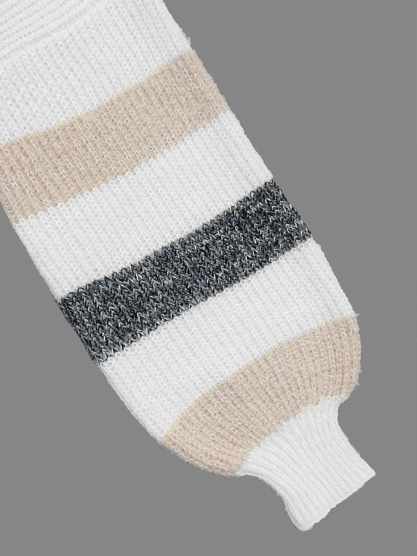 Close-up of a striped sweater sleeve with white, beige, and gray colors on a gray background.