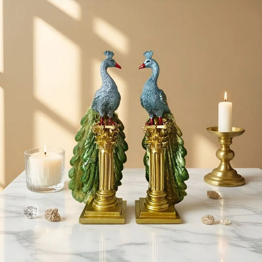 Decorative peacock statues on columns with candles in a warm setting