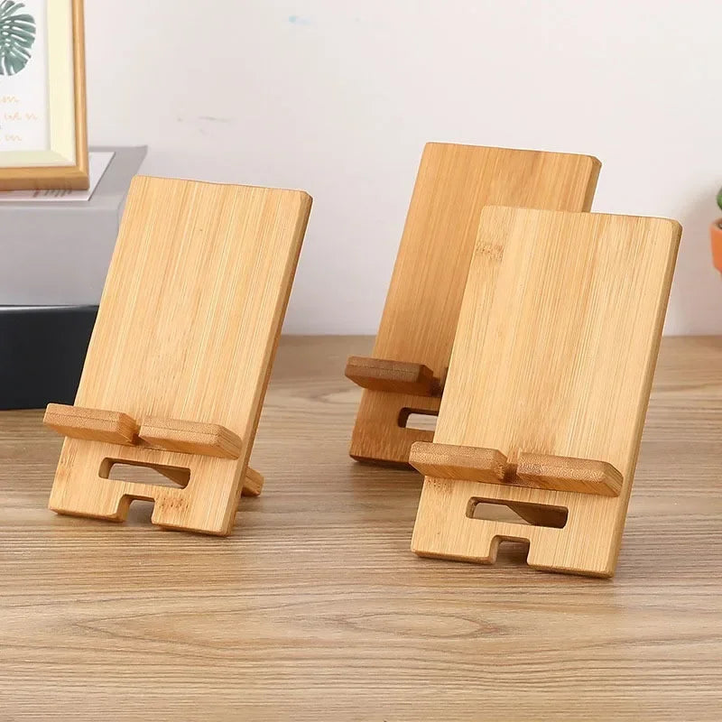 Three wooden phone stands on a wooden surface with a neutral background