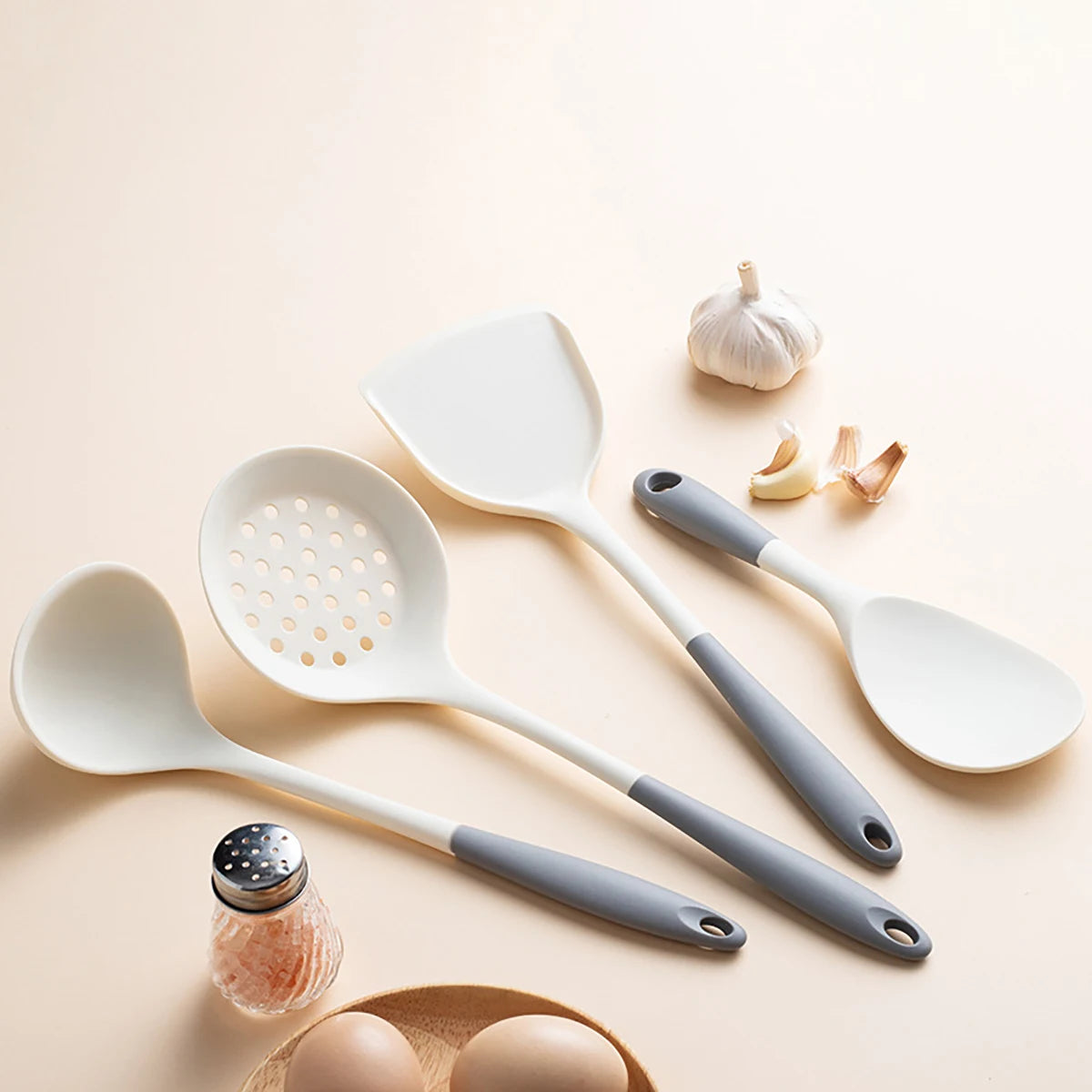 Set of white and gray kitchen utensils on a beige background
