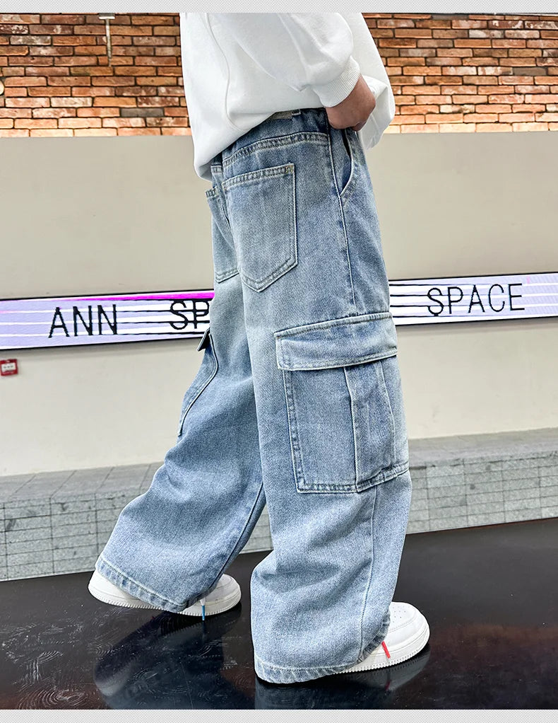 Person wearing light blue denim cargo pants with a brick wall background