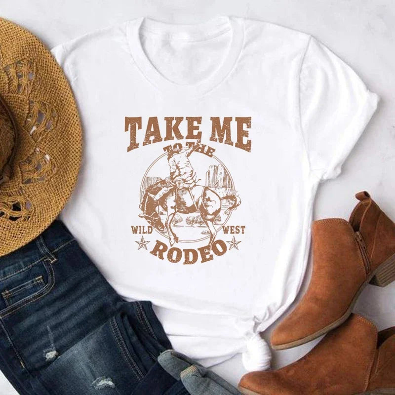 White t-shirt with 'Take Me to the Wild West Rodeo' design, paired with a straw hat and brown boots on a white background.