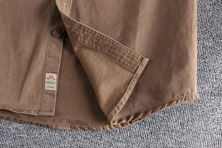 Brown shirt with a visible brand logo on a textured surface