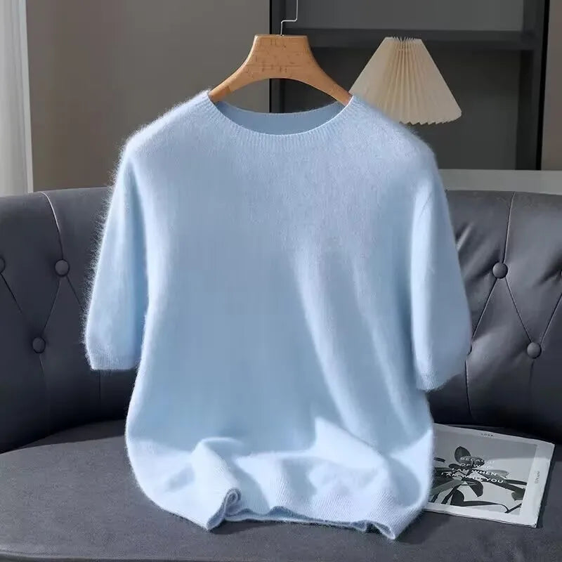 Light blue sweater on a hanger against a gray sofa background
