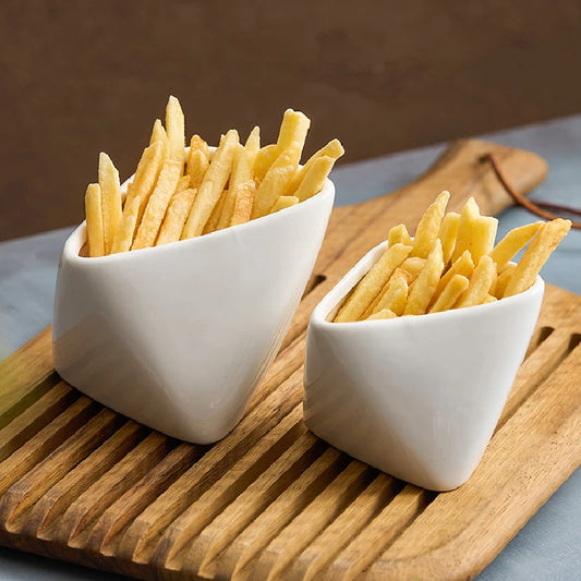 Two white ceramic bowls filled with french fries on a wooden board.