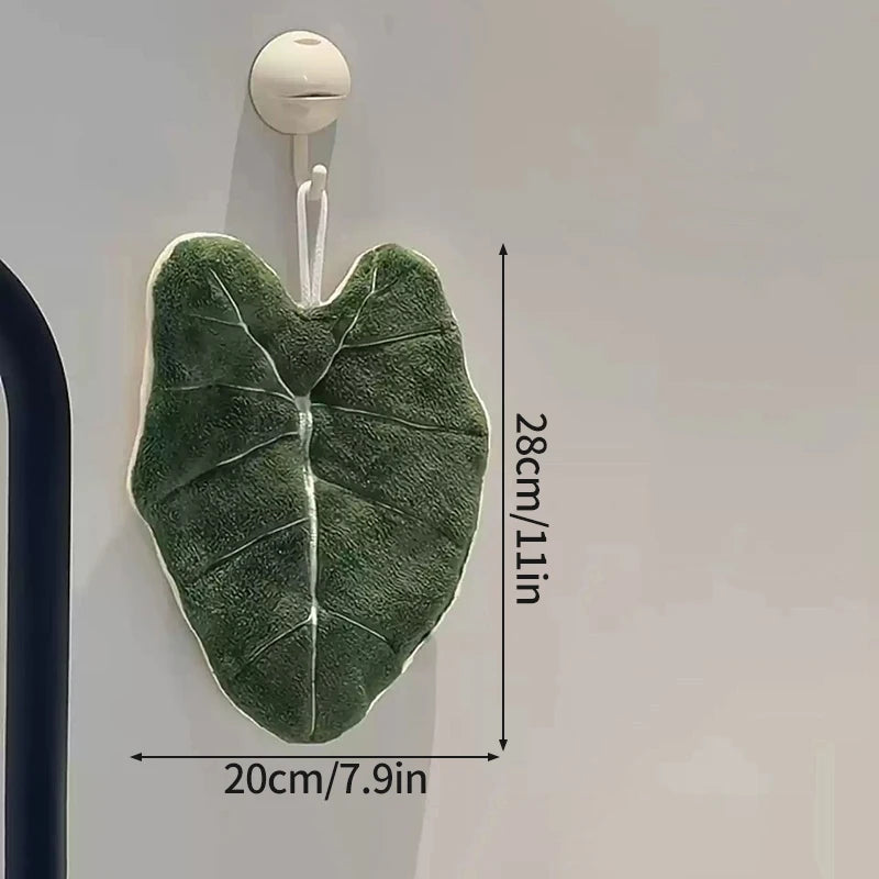 Green leaf-shaped hook on a white wall with measurements indicated.