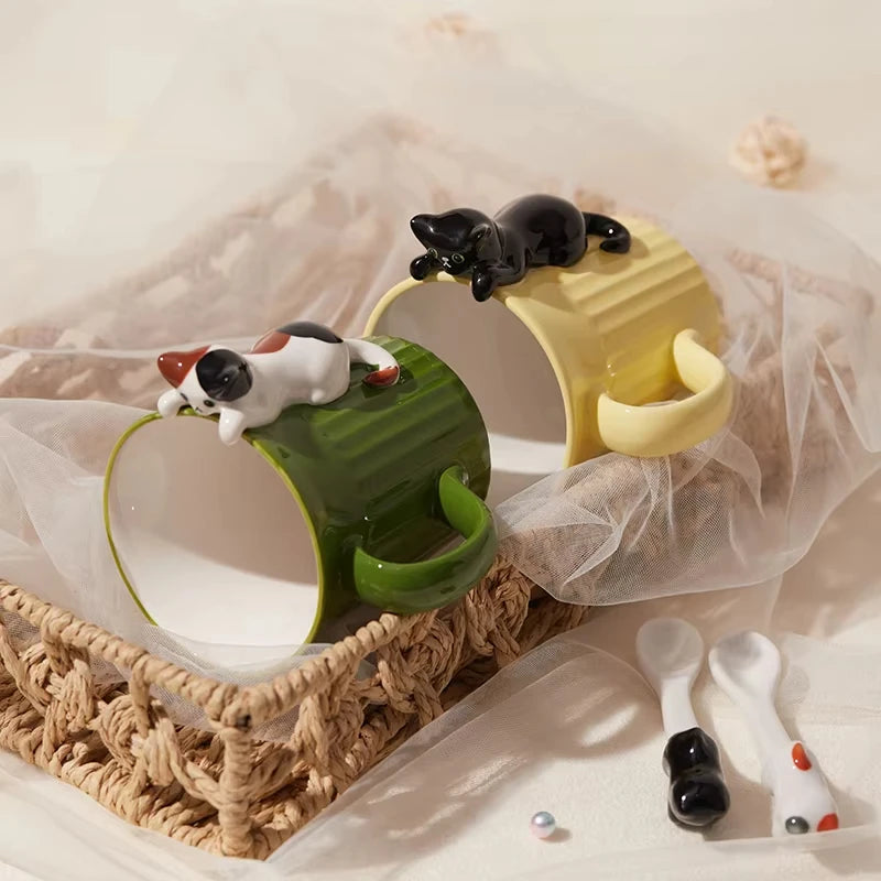 Green and yellow ceramic cat mugs with a 3D cat climbing over the rim.