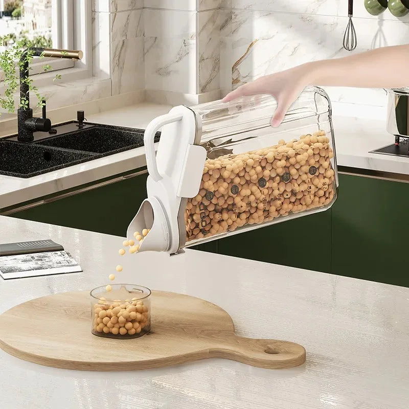 Person using a kitchen container to pour beans onto a cutting board in a kitchen.