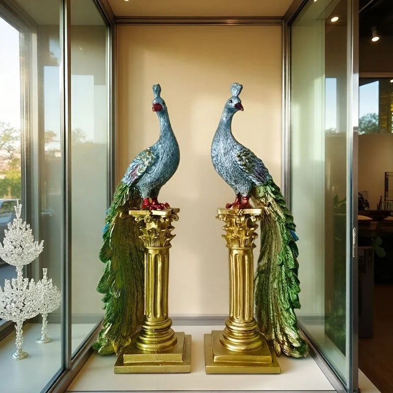 Decorative peacock statues on gold pedestals in a display case.