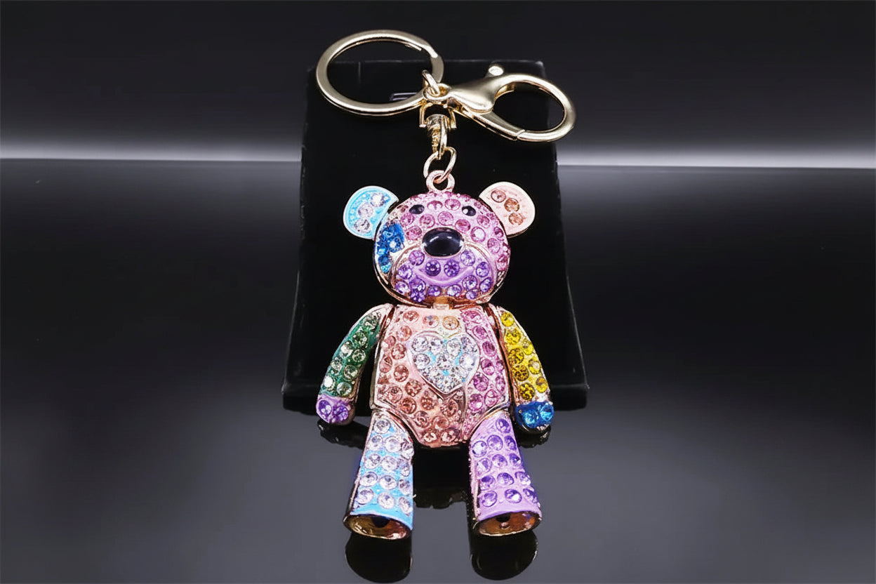 Colorful teddy bear keychain with rhinestones on a black background